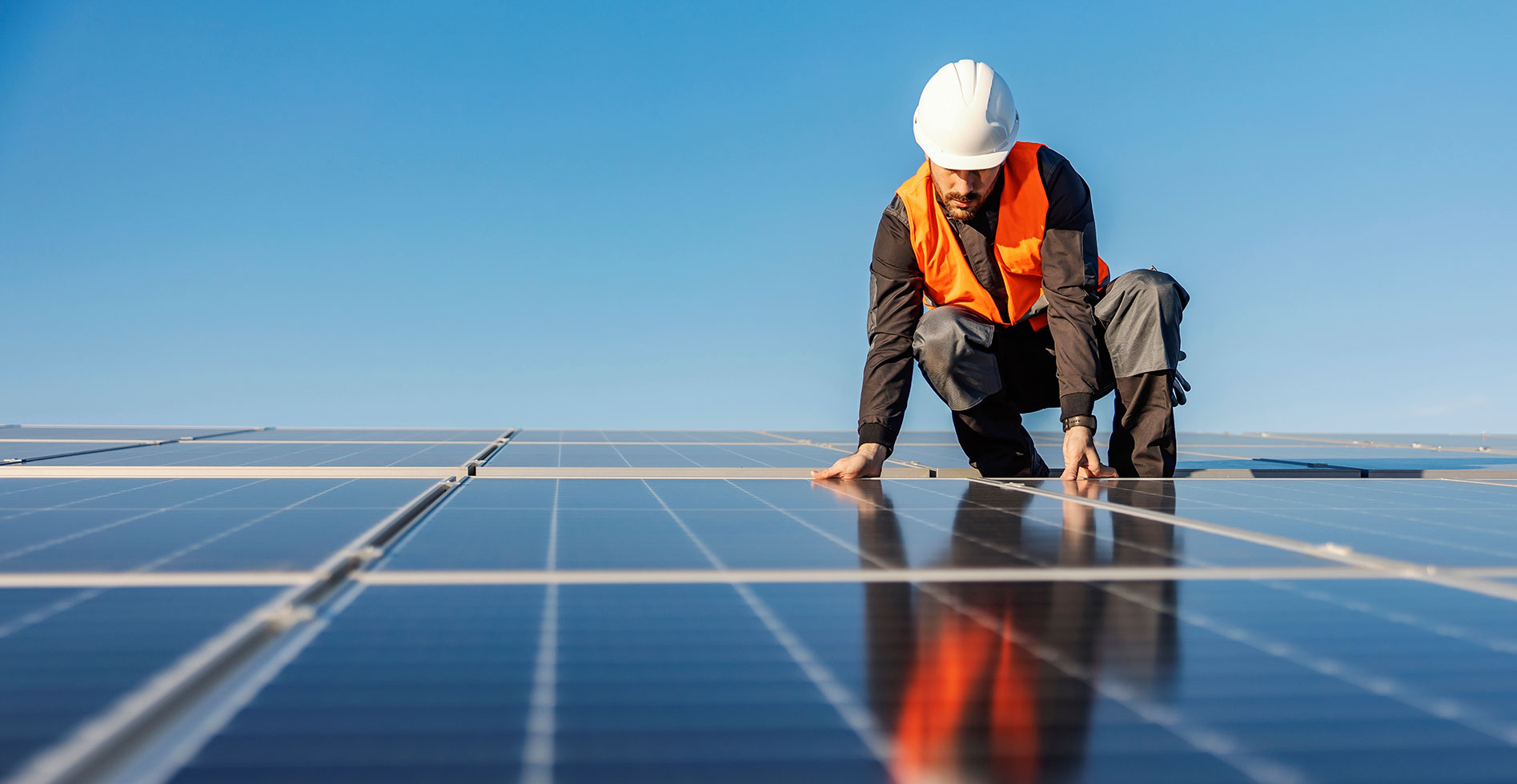 roofer inspecting solar panels on the roof