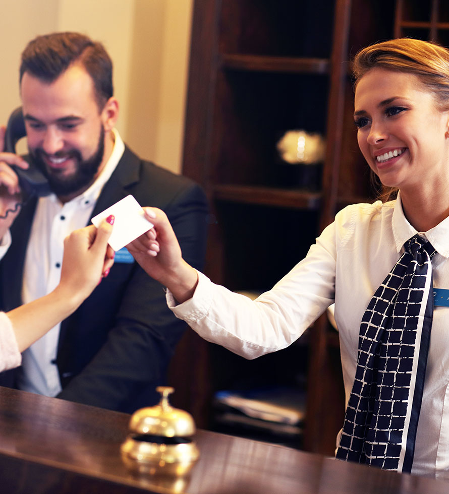 smiling hotel clerk giving the room key to the guest