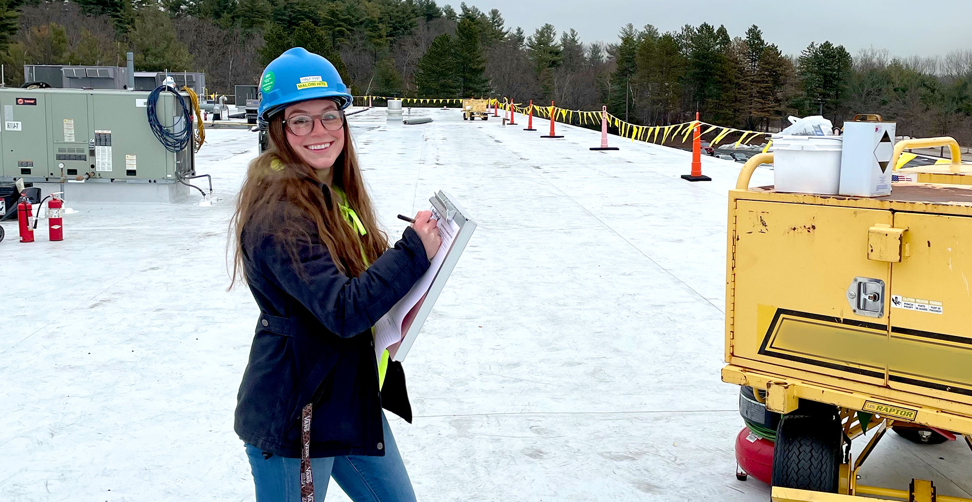 female commercial roofing specialist with a clipboard